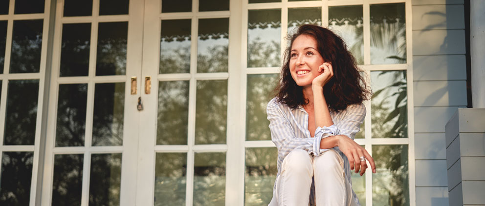 Young woman sitting on her front porch