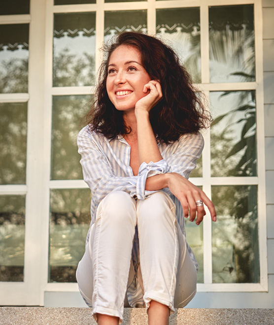 Young woman sitting on her front porch