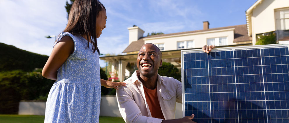 Man showing his daughter the solar panels he bought with his HELOC from ServU