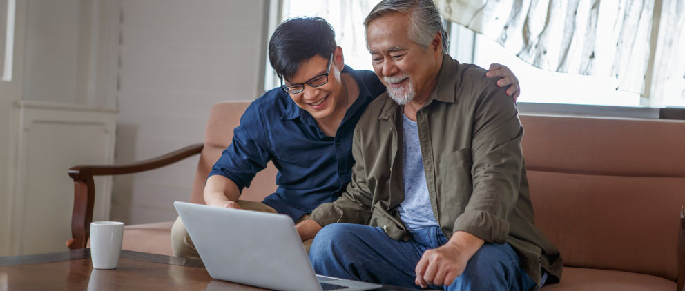 Man showing his father how to sign-up for online banking services