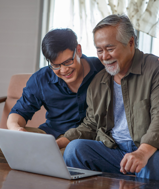 Man showing his father how to sign-up for online banking services