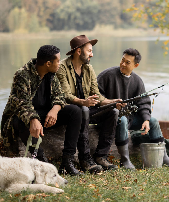 Three men and a dog fishing by a lake