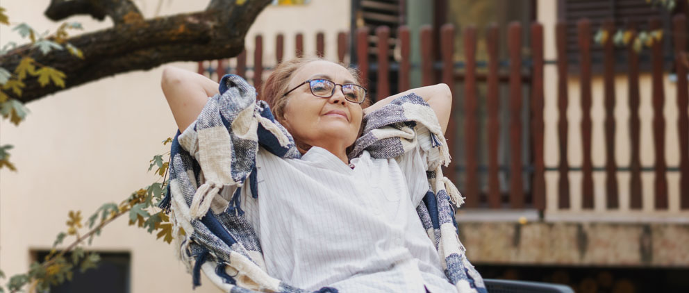 Woman relaxing in a chair next to her front porch