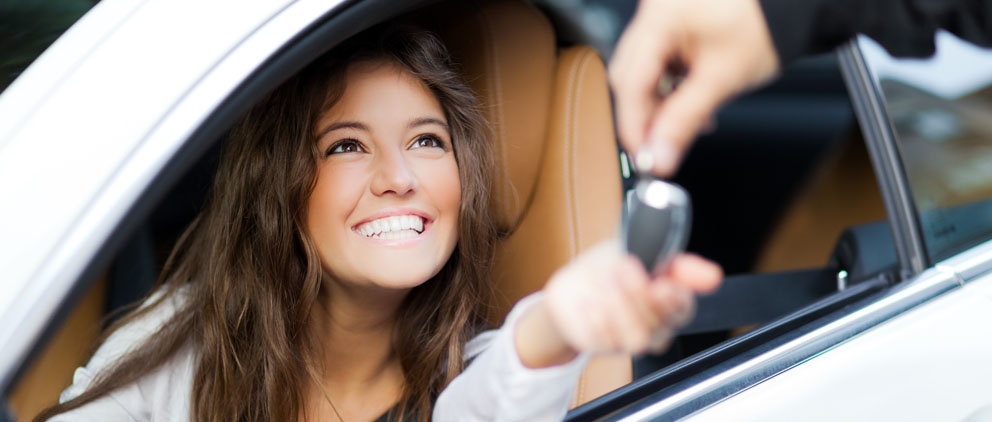 Young woman getting the keys to her new car