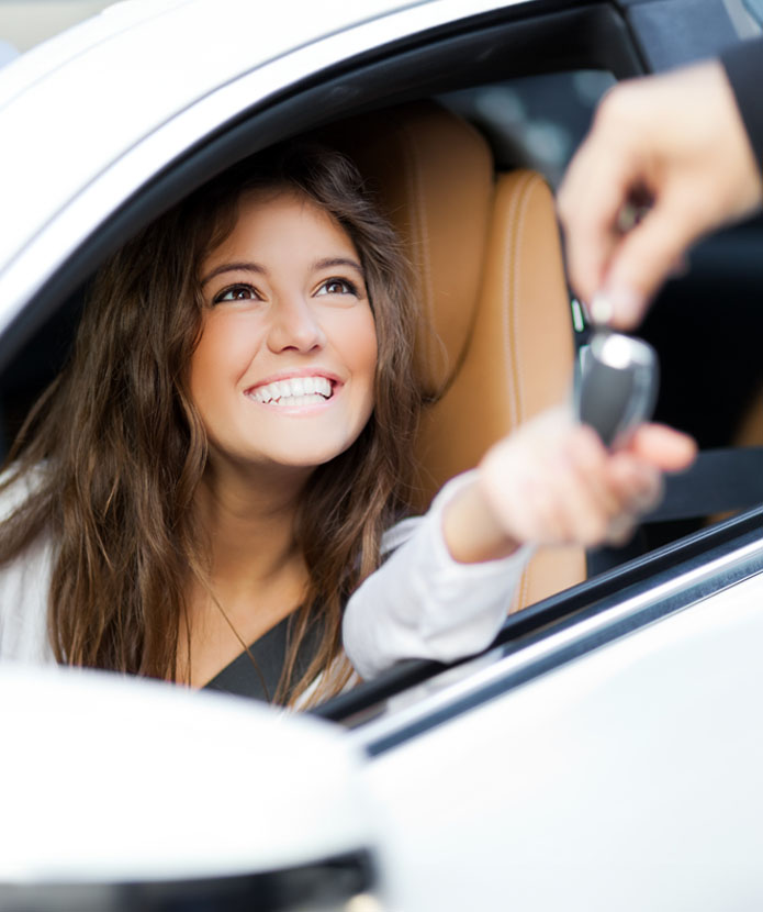 Young woman getting the keys to her new car