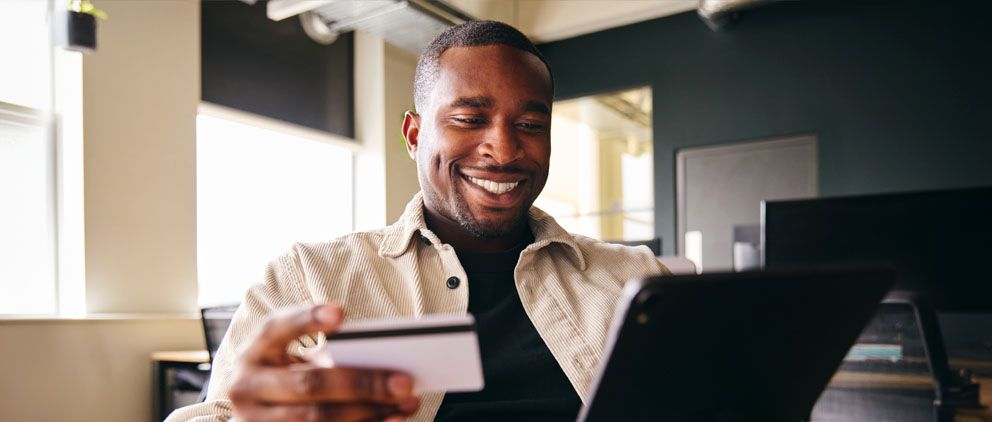 Man shopping on a tablet with his ServU Visa Credit Card