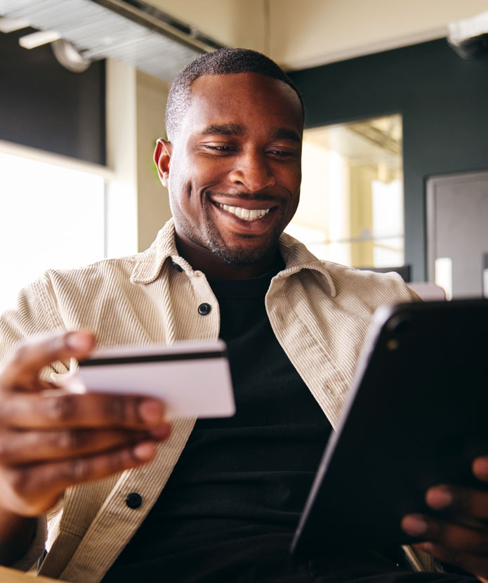 Man shopping on a tablet with his ServU Visa Credit Card