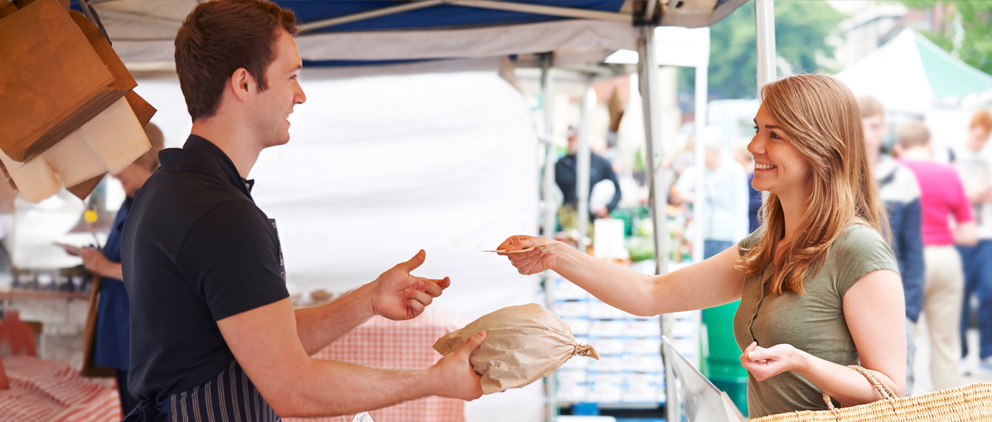 A woman buying bread at a farmers market