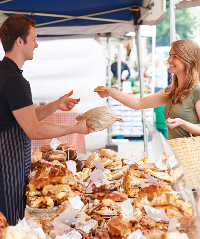 A woman buying bread at a farmers market